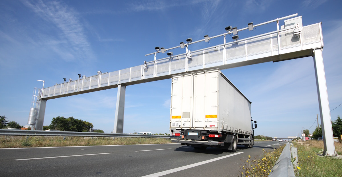 LKW fährt unter Mautbrücke auf Autobahn hindurch LKW fährt unter Mautbrücke auf Autobahn hindurch